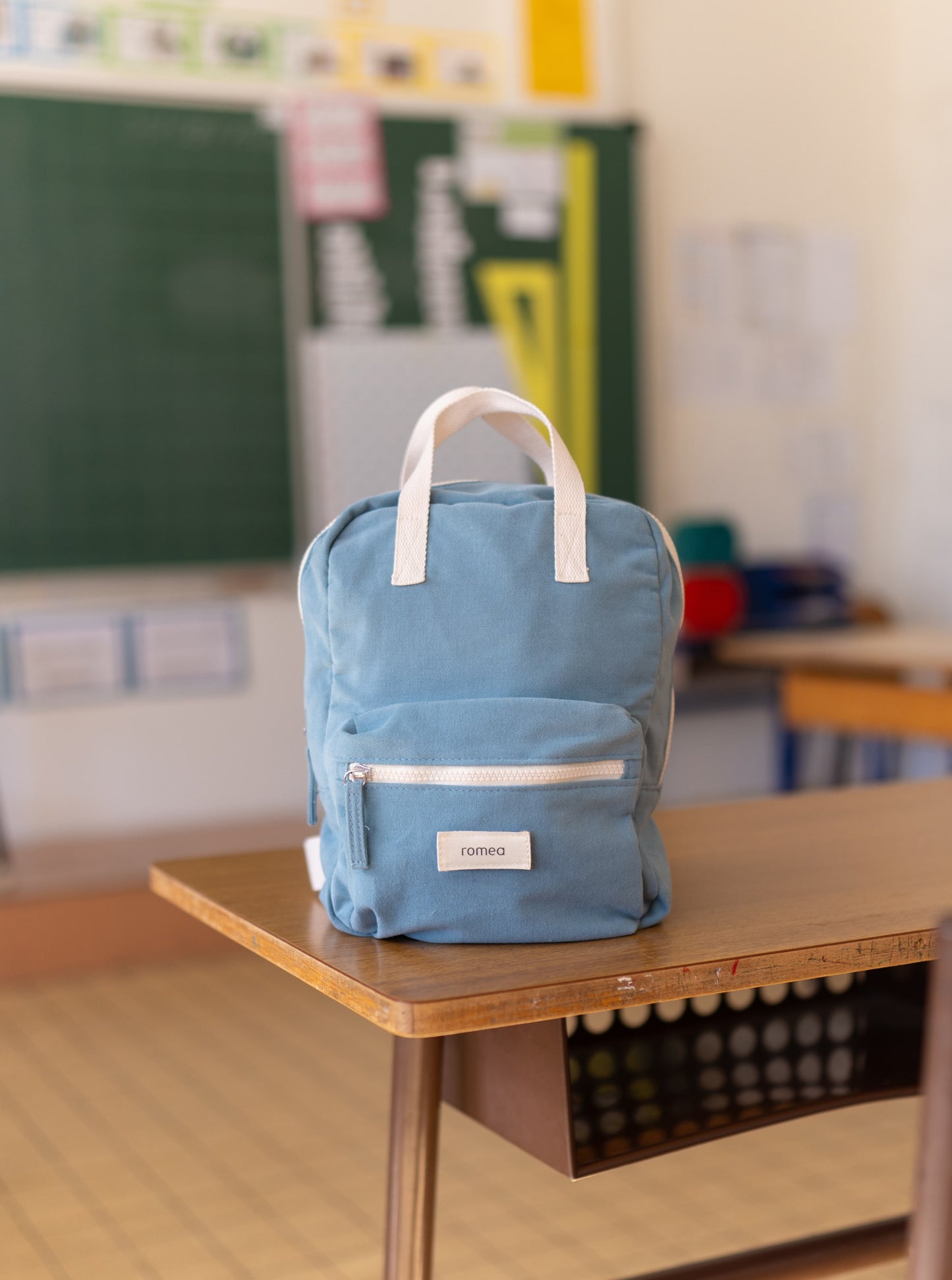 sac de couleur bleu posé sur une table de classe d'école