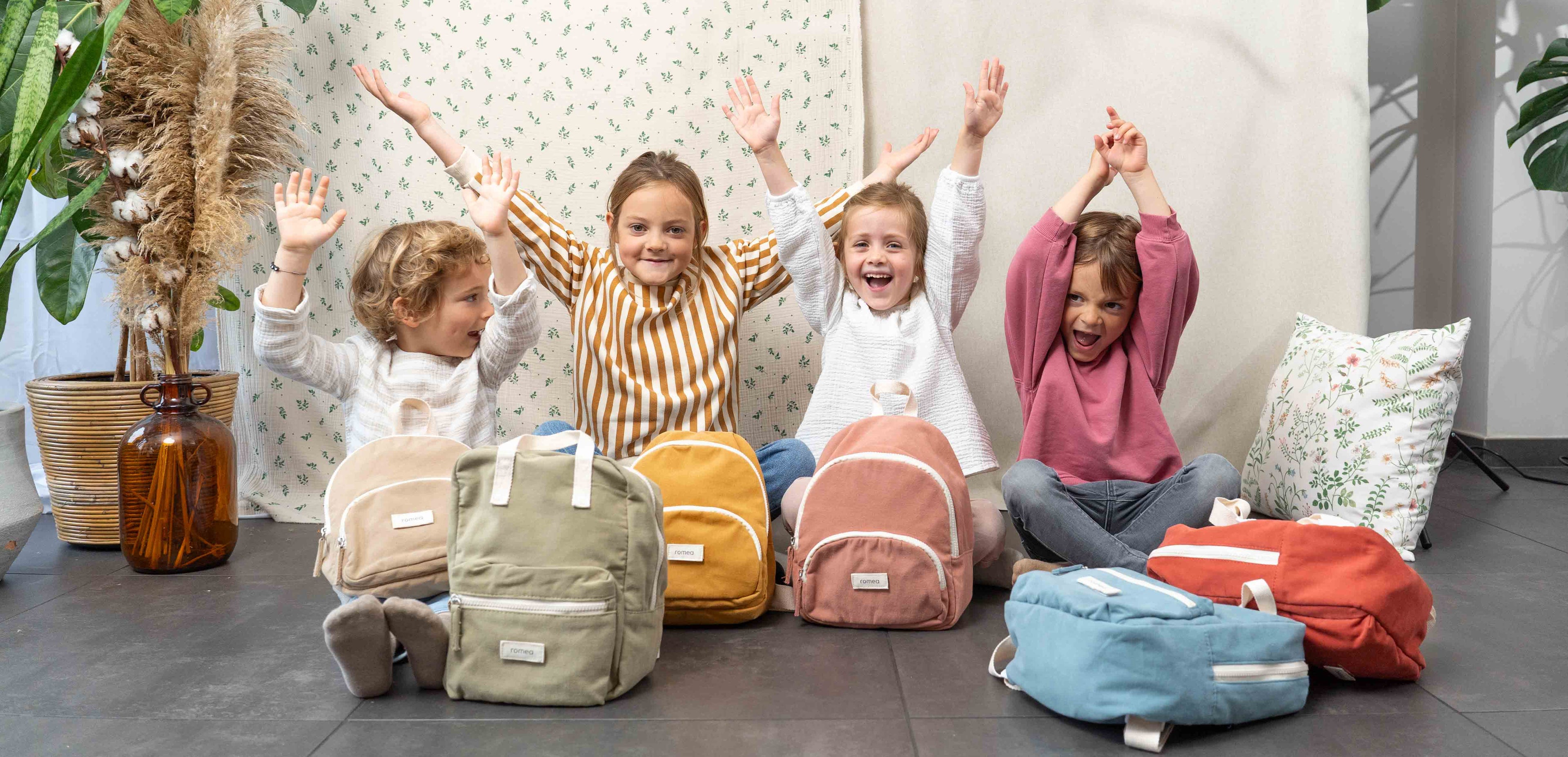 un groupe d'enfant heureux avec les sacs à dos romea