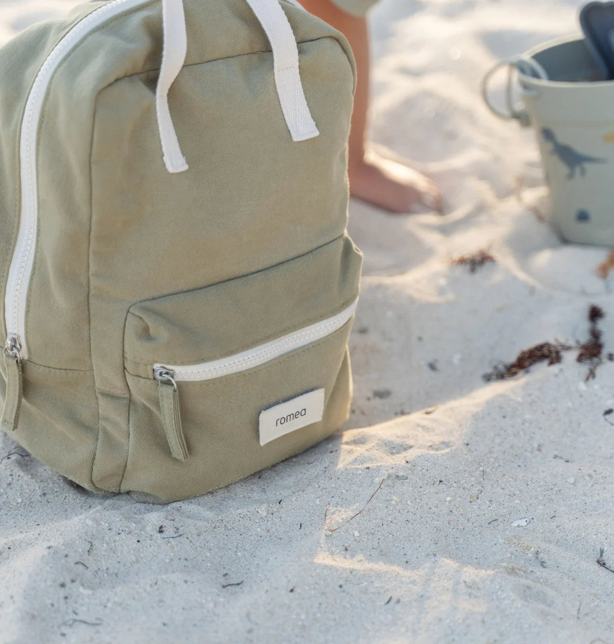 sac à dos de couleur vert dans le sable sur le coté 