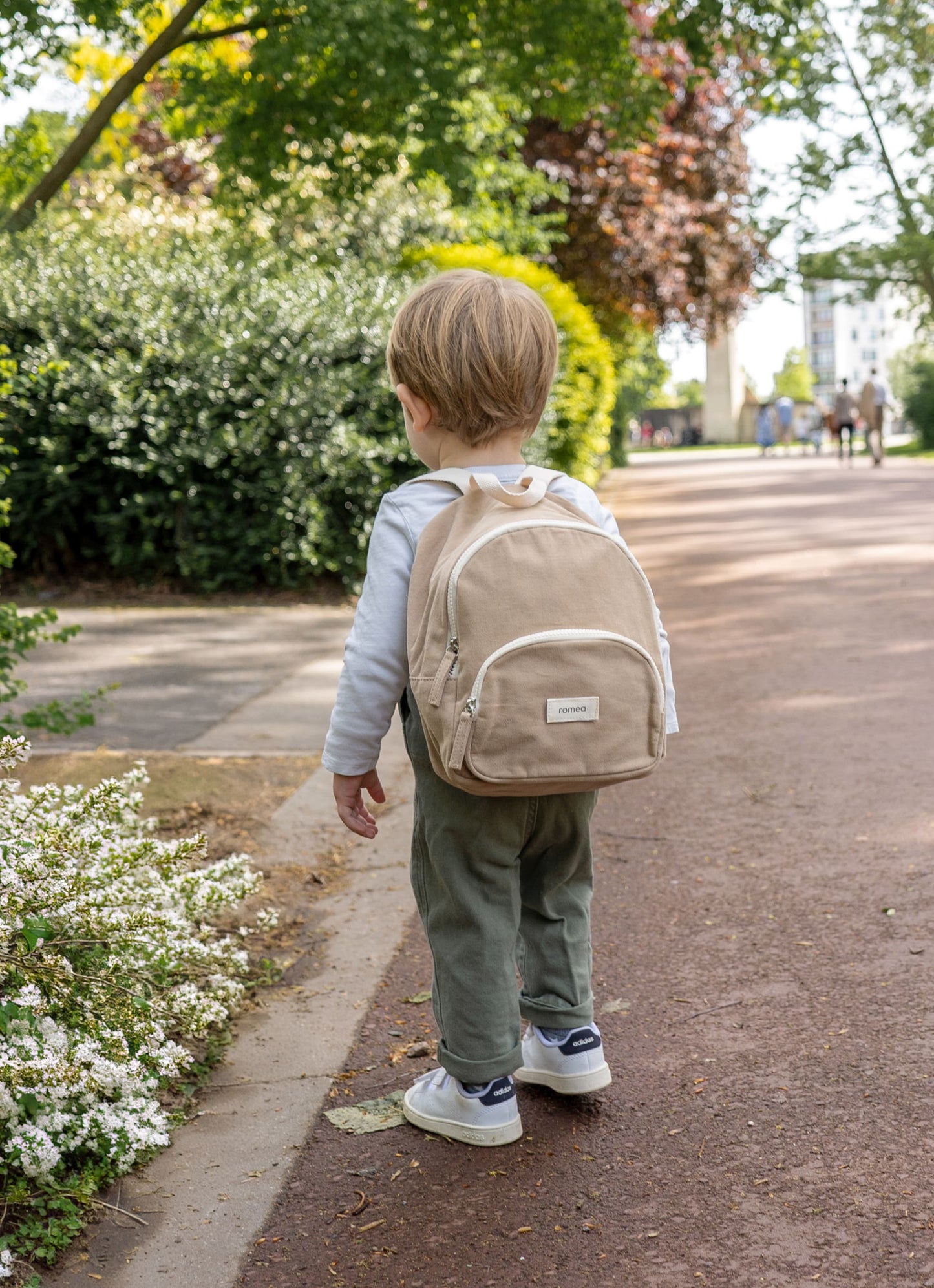 sac à dos de couleur beige porté de dos par un garçon
