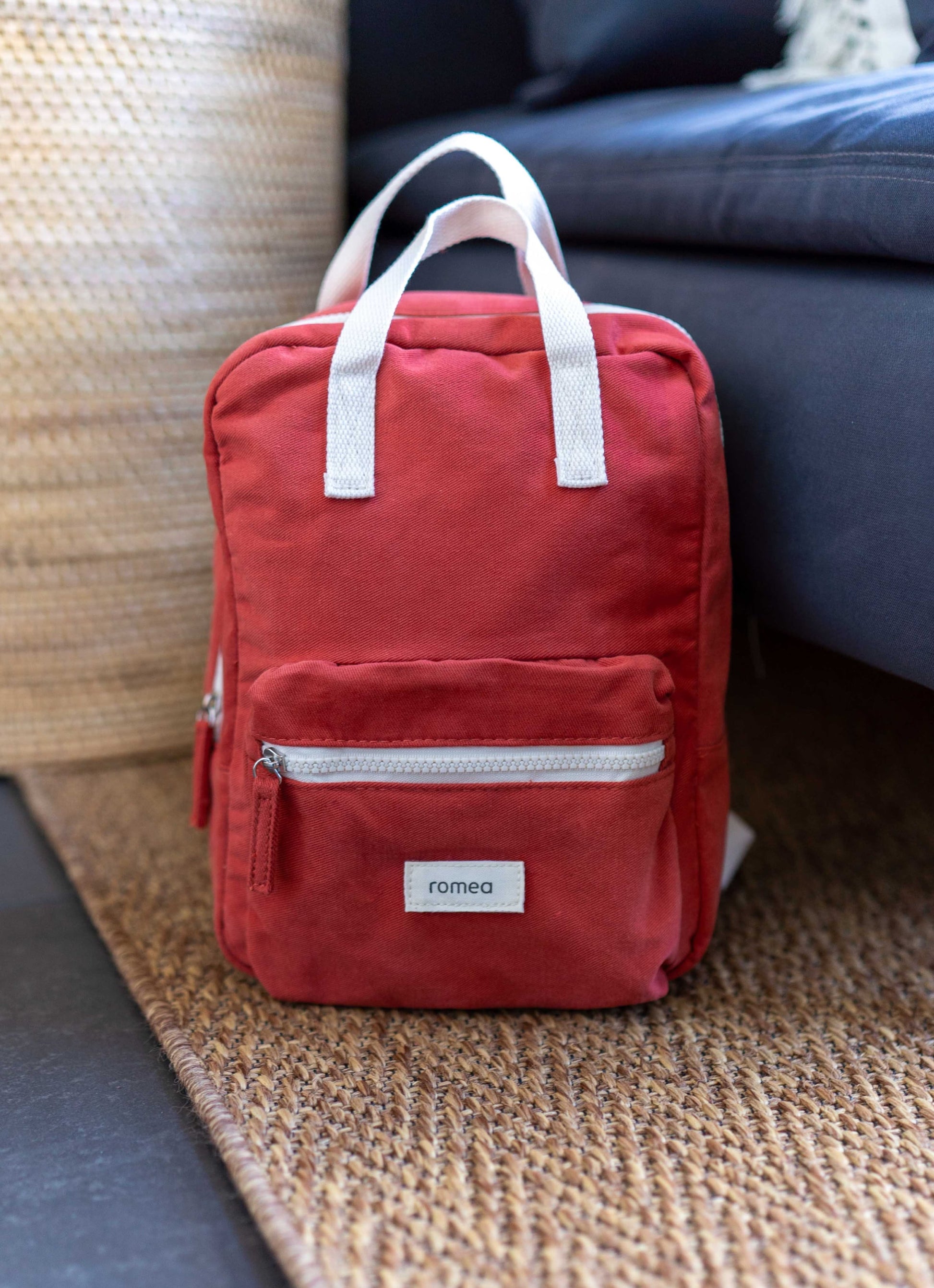 sac rouge brique posé sur un tapis