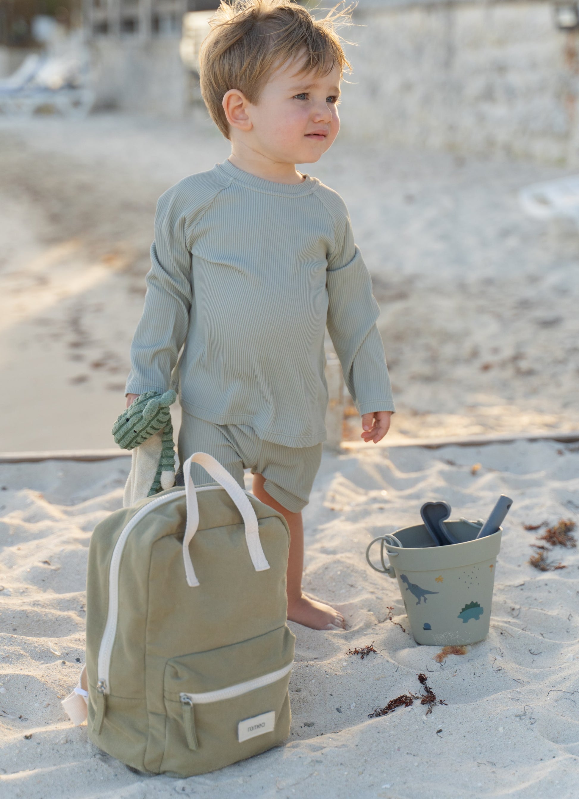 garçon à la plage avec un sac à dos romea vert kaki 